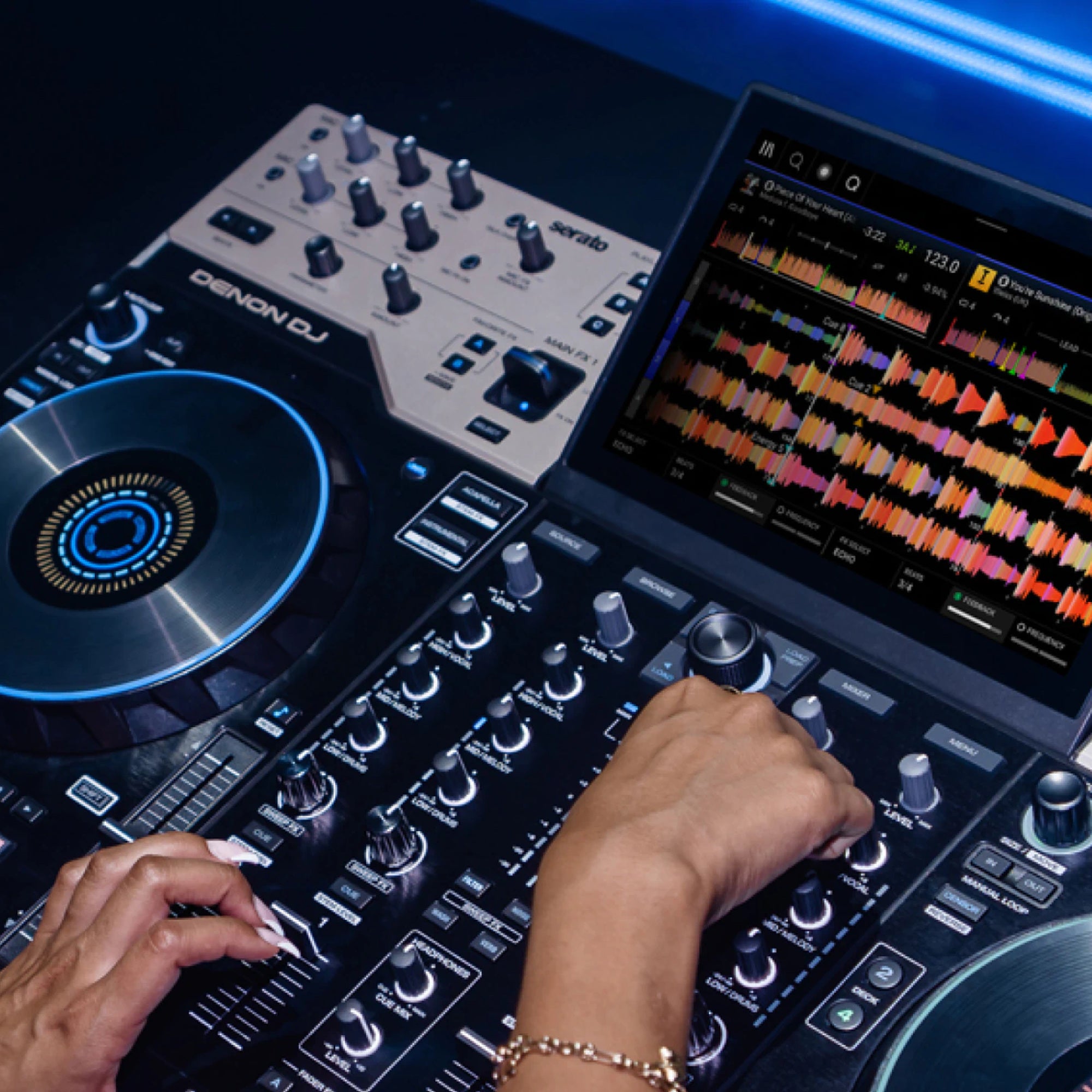 Denon DJ Prime 4 G2 four-deck standalone DJ system with waveform touchscreen and lit jog wheel in a club booth