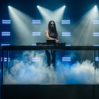 Denon DJ Prime 4 G2, DJ performing on stage with DMX lighting