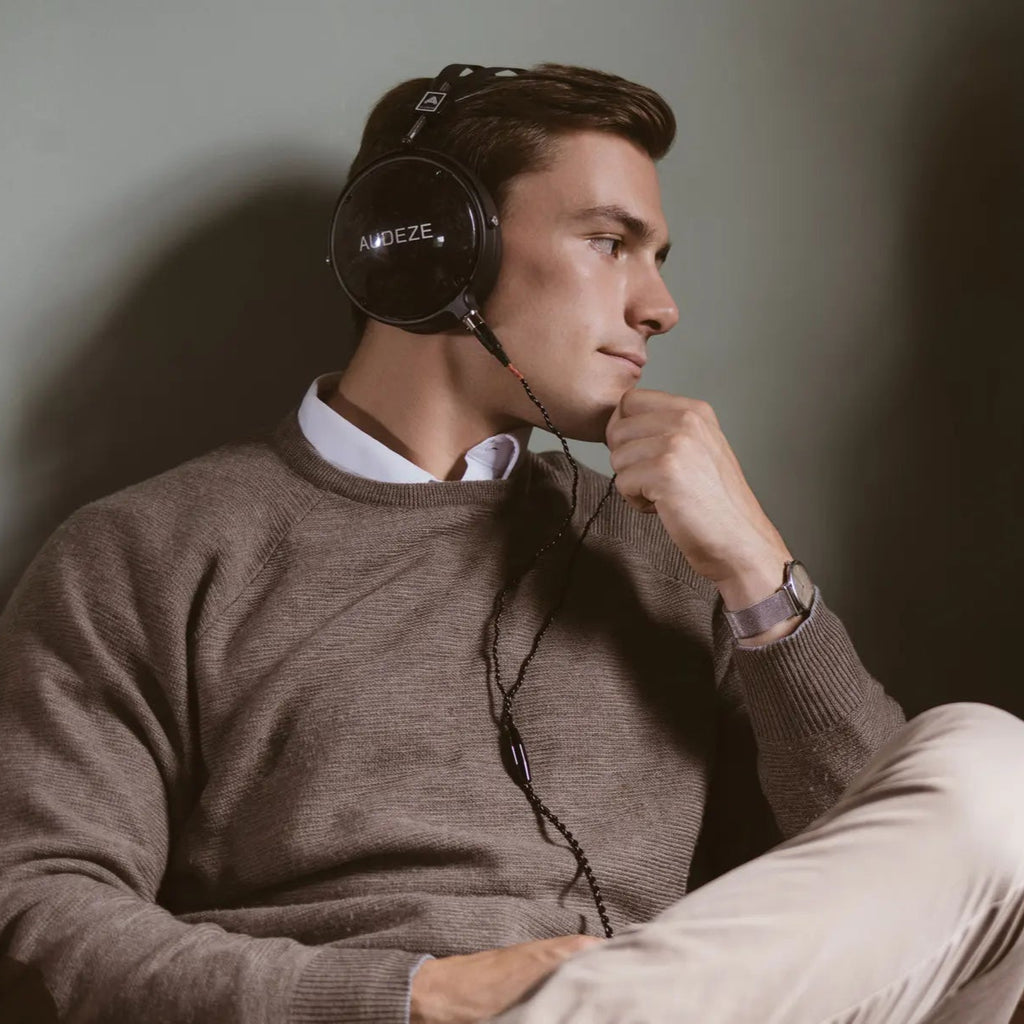 Audeze LCD-2 Classic closed-back head-fi headphones with leather-free ear cups and sleek black design, resting on a white surface.