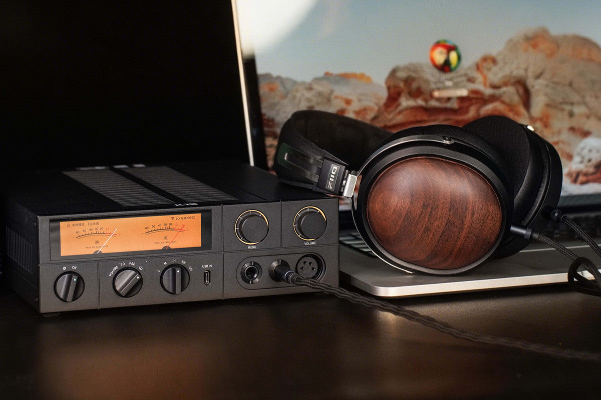 Black FiiO K15 headphone amplifier and DAC with USB connection, featuring a sleek design and high-quality audio components.
