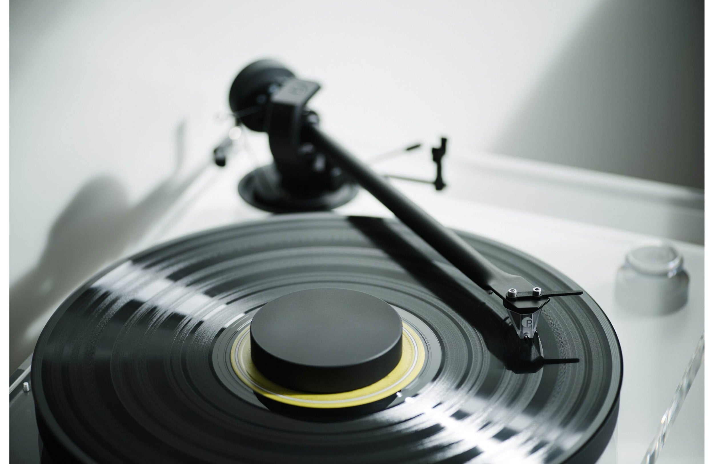 Pro-Ject XA B turntable with wooden plinth and tonearm, close-up view of the high-quality audio equipment.