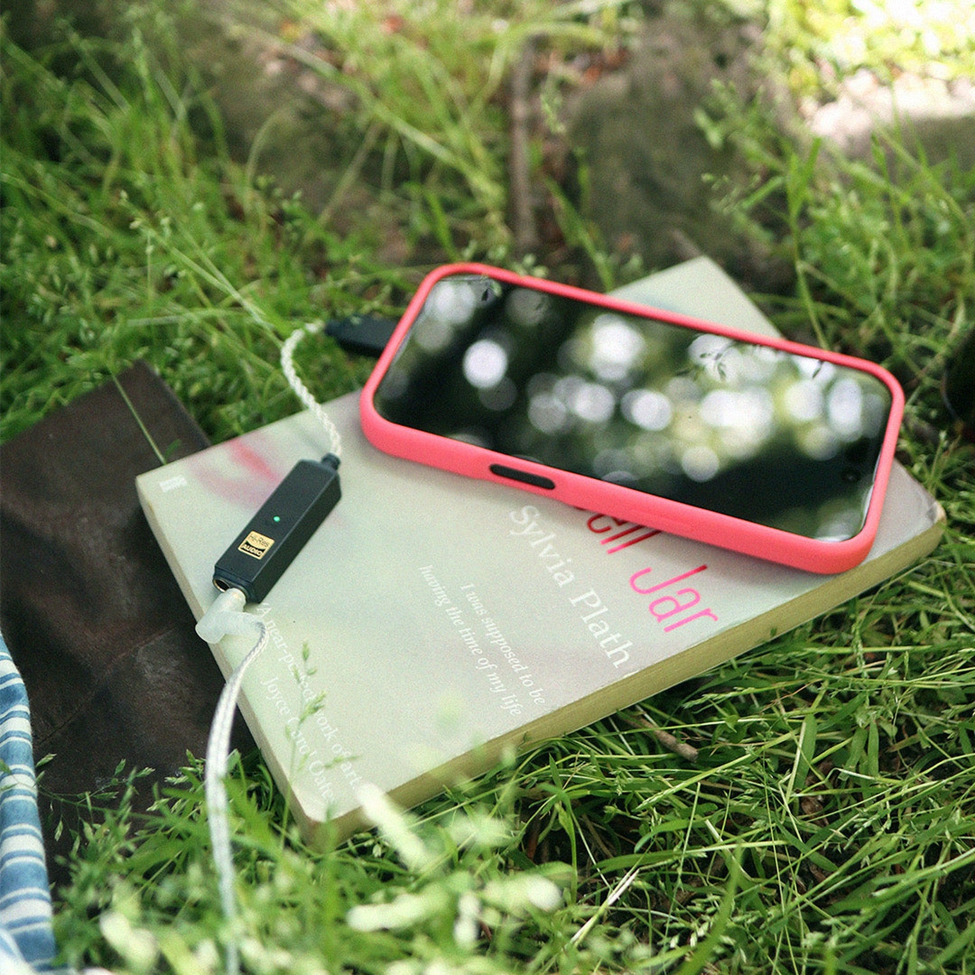 iFi Audio GO link 2 Max with phone on a book