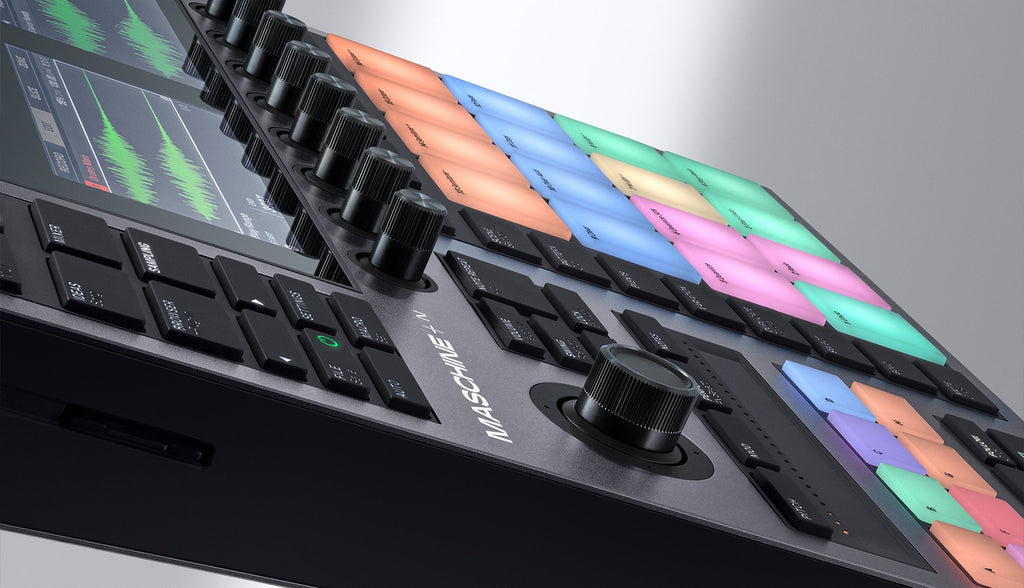Native Instruments Maschine+ drum machine and sampler with colorful pad interface and control knobs on a sleek black device.