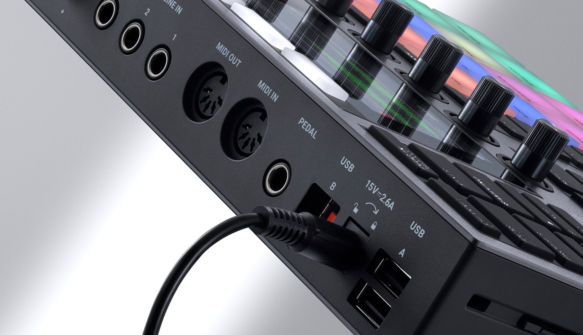 Native Instruments Maschine+ drum machine and sampler with touch-sensitive pads, display screen, and control knobs.