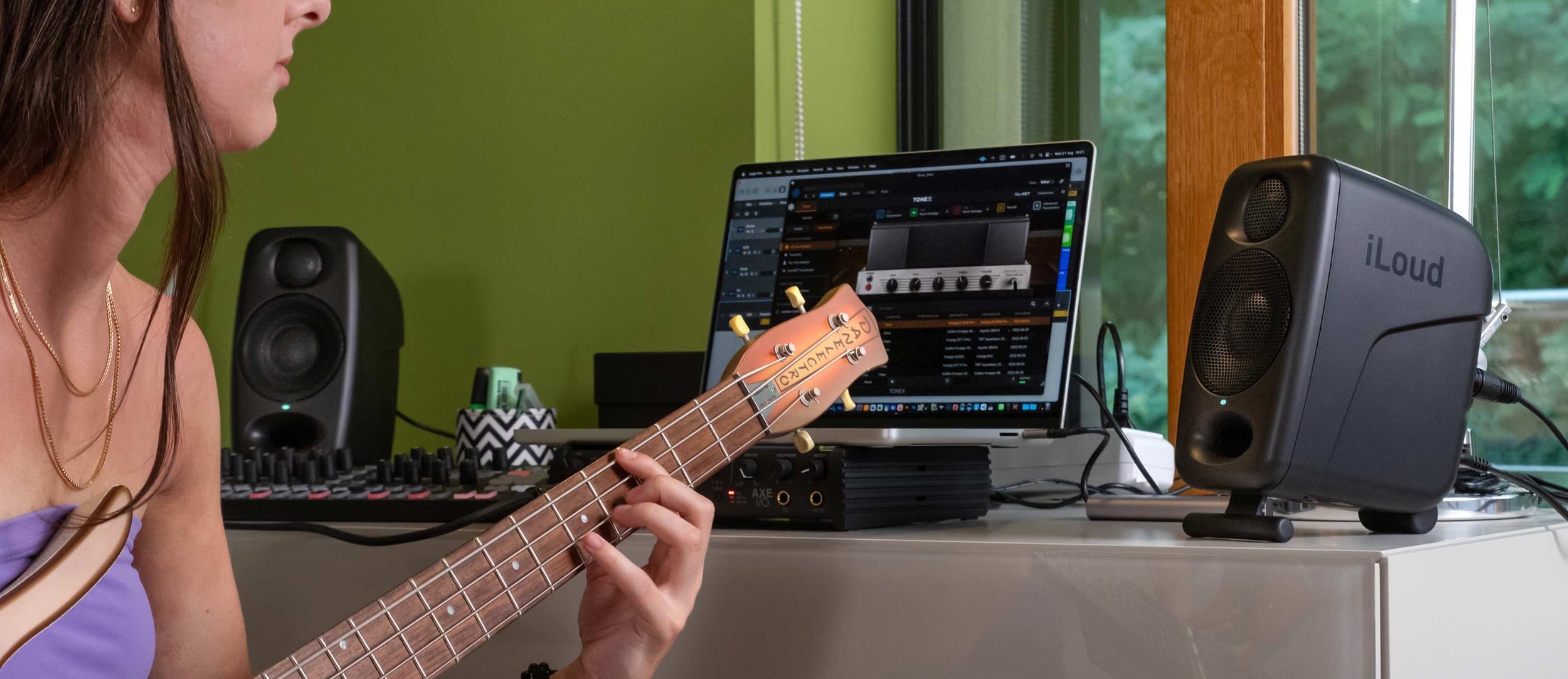 IK Multimedia iLoud Micro Monitor Pro active nearfield speakers on a desk, showcasing compact design and control panel.