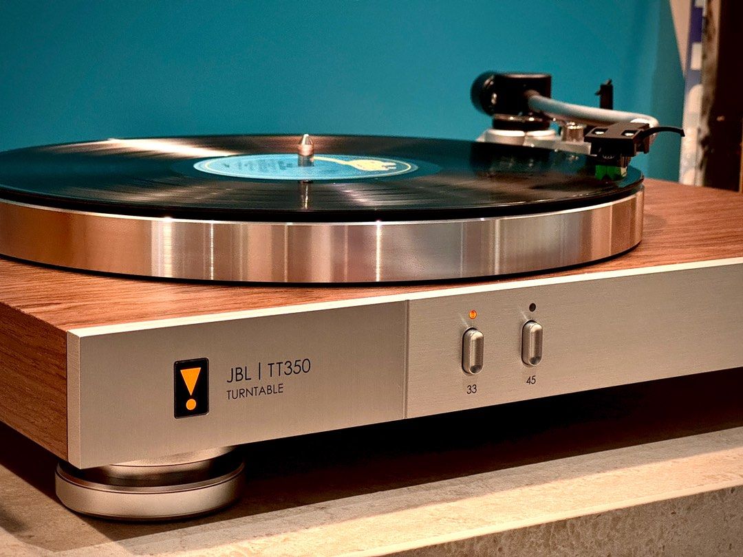 JBL TT350 classic turntable with wood finish and built-in speaker, showing the sleek design and control knobs.