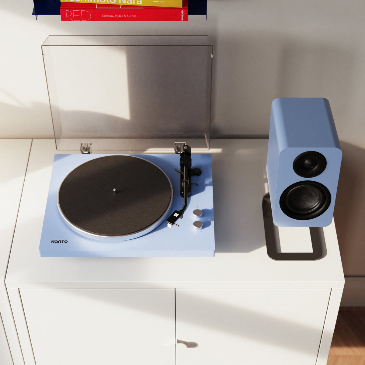 Kanto Audio OBI3 Gen 2 turntable, Ice Blue, on a white sideboard with matching speaker