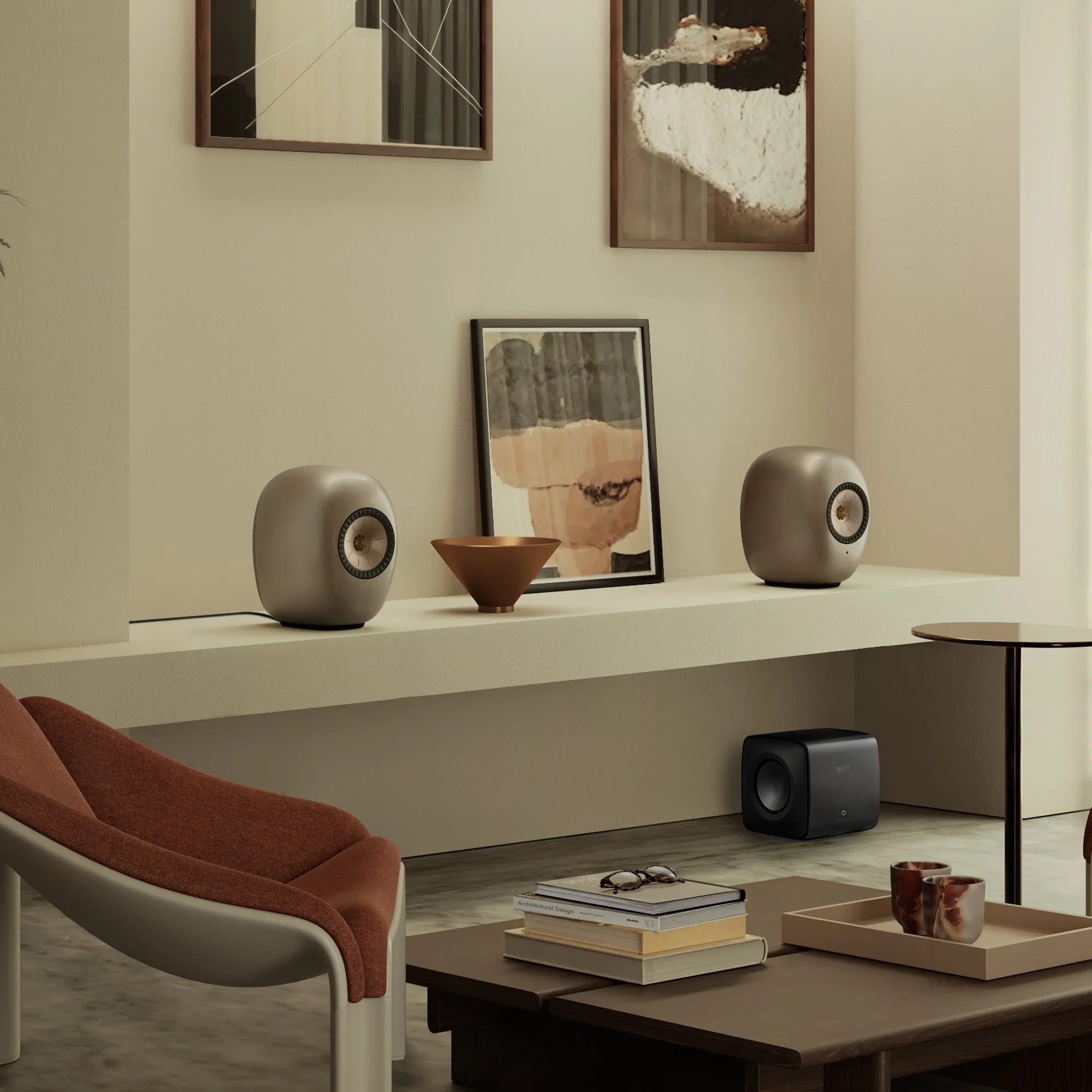 KEF LS Luxe in Dusk Titanium on a living room shelf with artwork and a KEF subwoofer