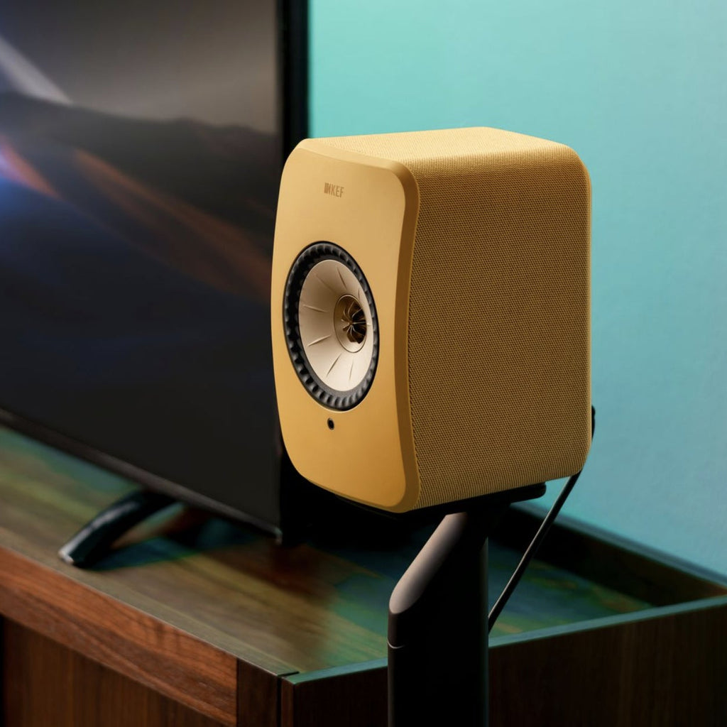 KEF LSX II wireless bookshelf speakers, in amber haze on a desk
