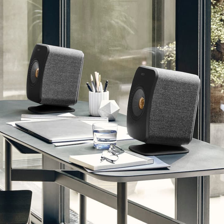 KEF LSX II wireless bookshelf speakers, in carbon black on a desk
