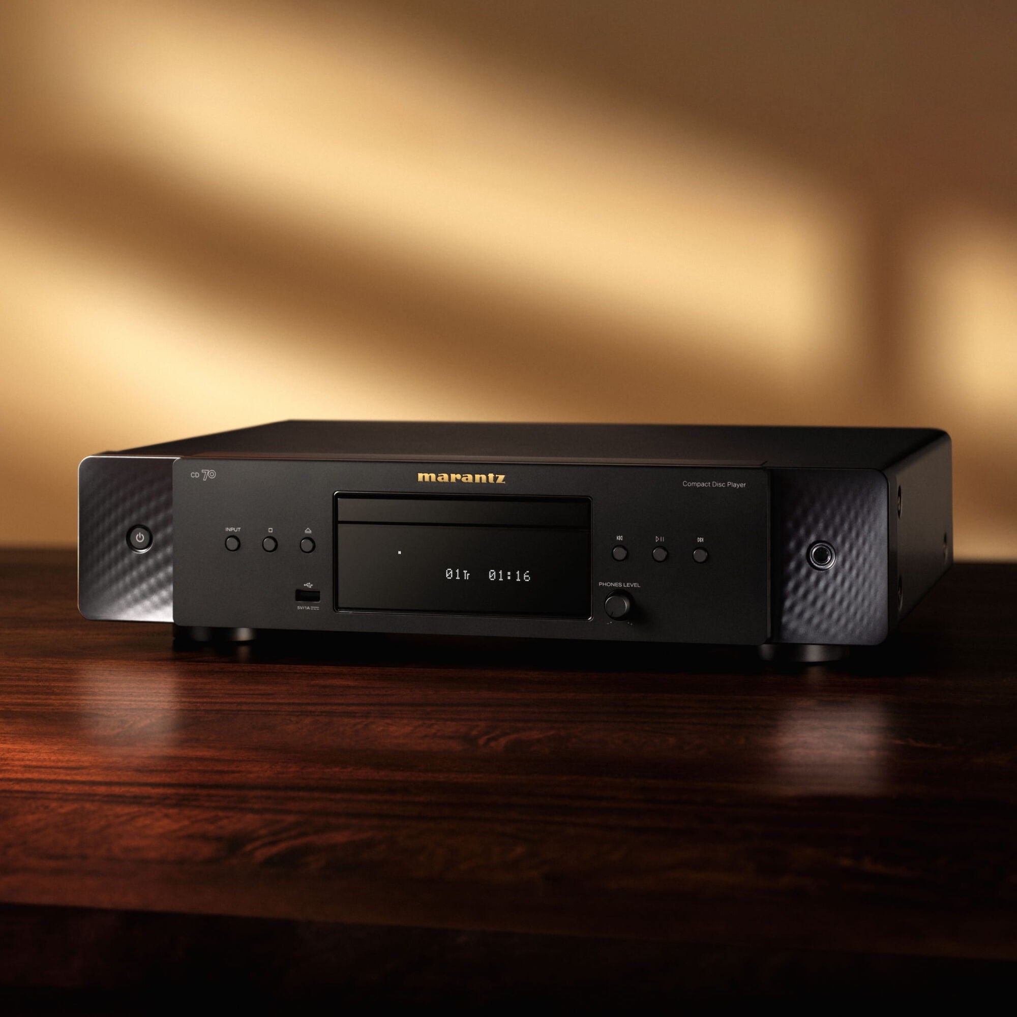 Marantz CD 70 Black on a wooden console in a warmly lit living room