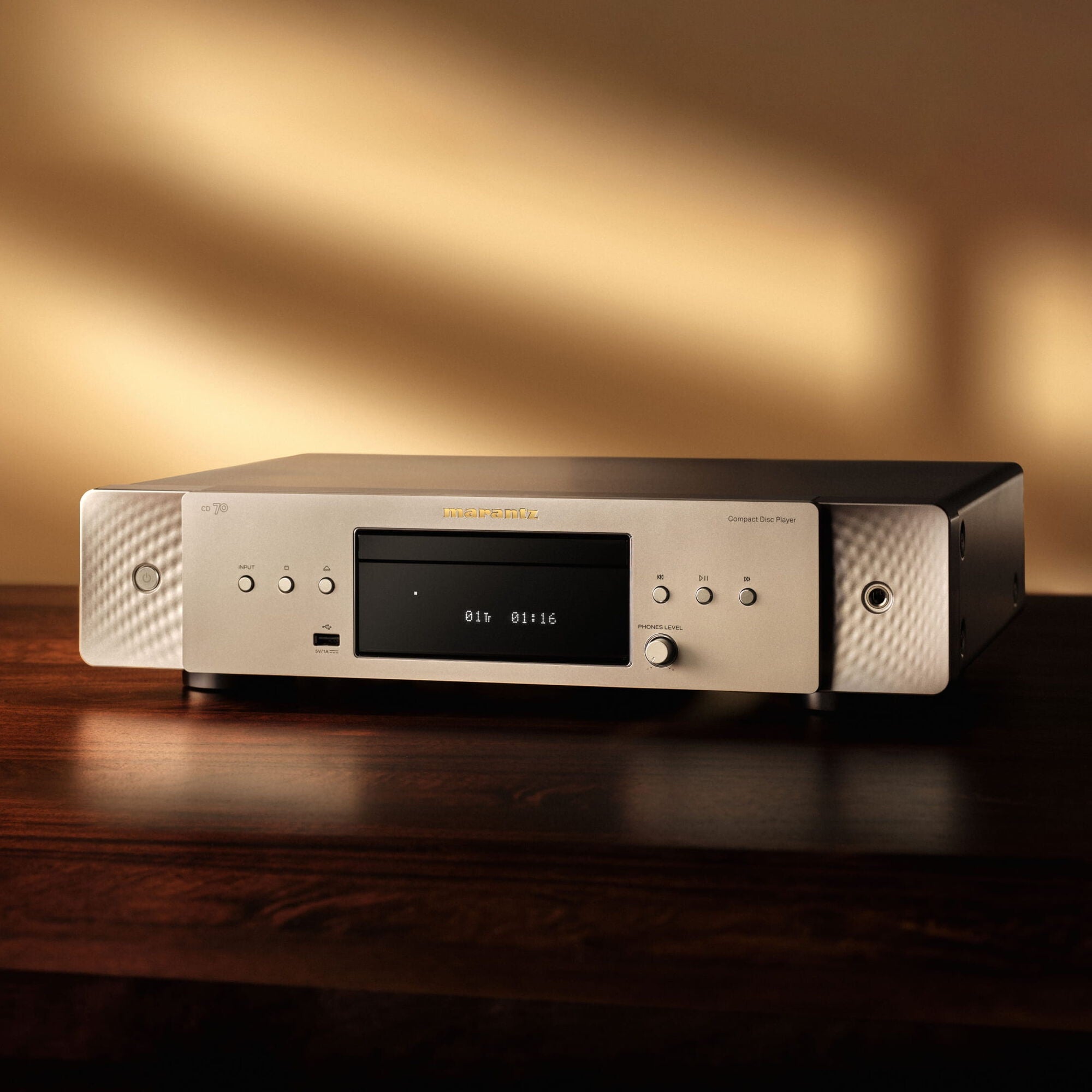 Marantz CD 70 Silver-Gold on a wooden console in a warmly lit living room