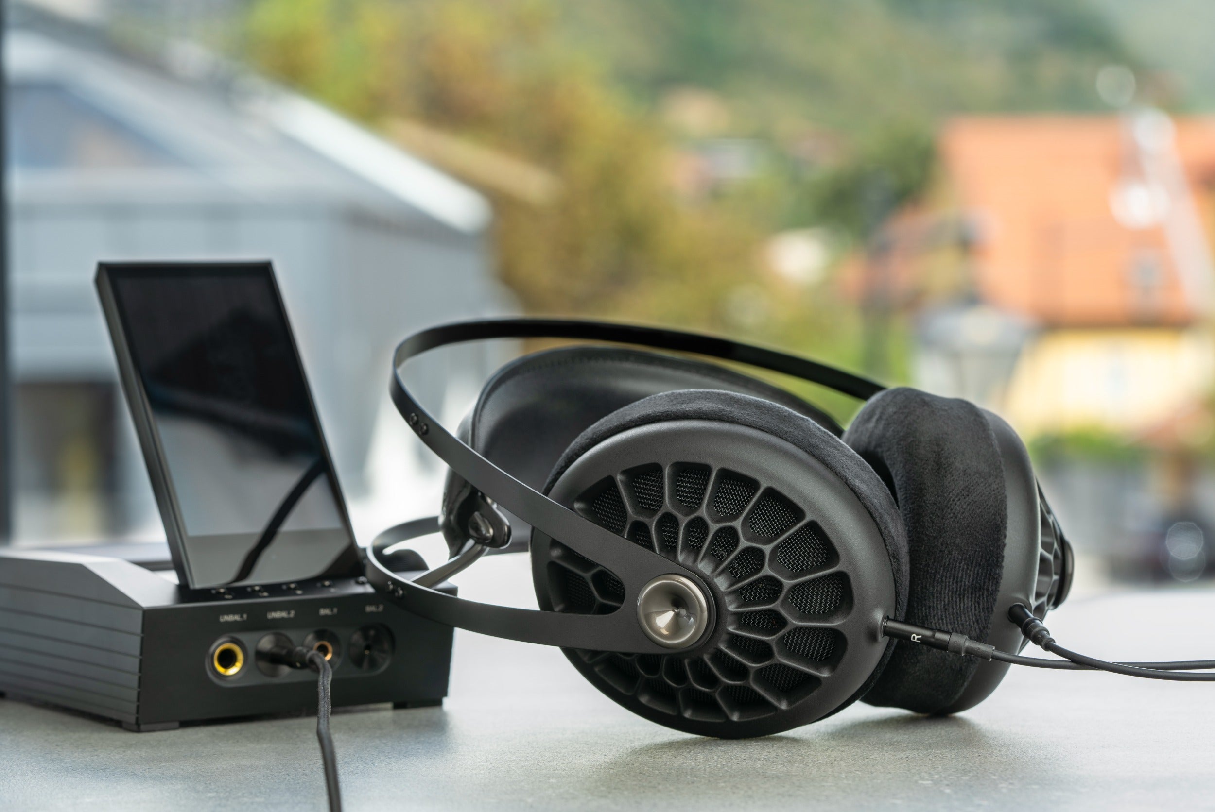 Close-up of Meze Audio 105 AER wired headphones with sleek black ear cups and a flexible headband, showcasing modern audio design.