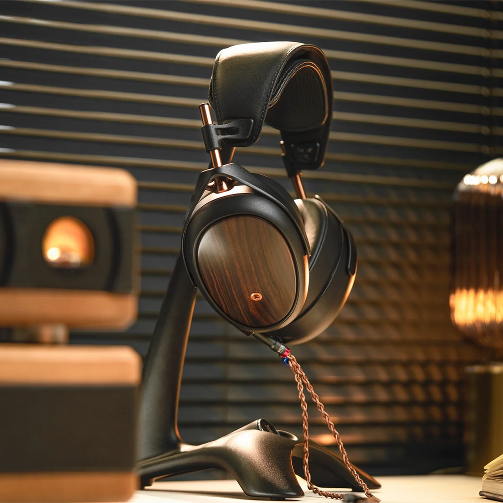 Close-up of Meze Audio Liric wired headphones showing the sleek black ear cups and detailed ear cushion design.