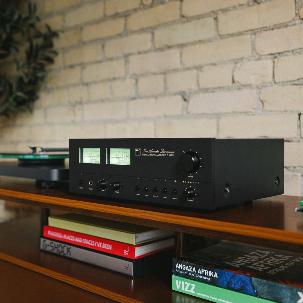 NAD C 3030S stereo amplifier with sleek black front panel and large volume knob, showcasing high-quality audio equipment design.