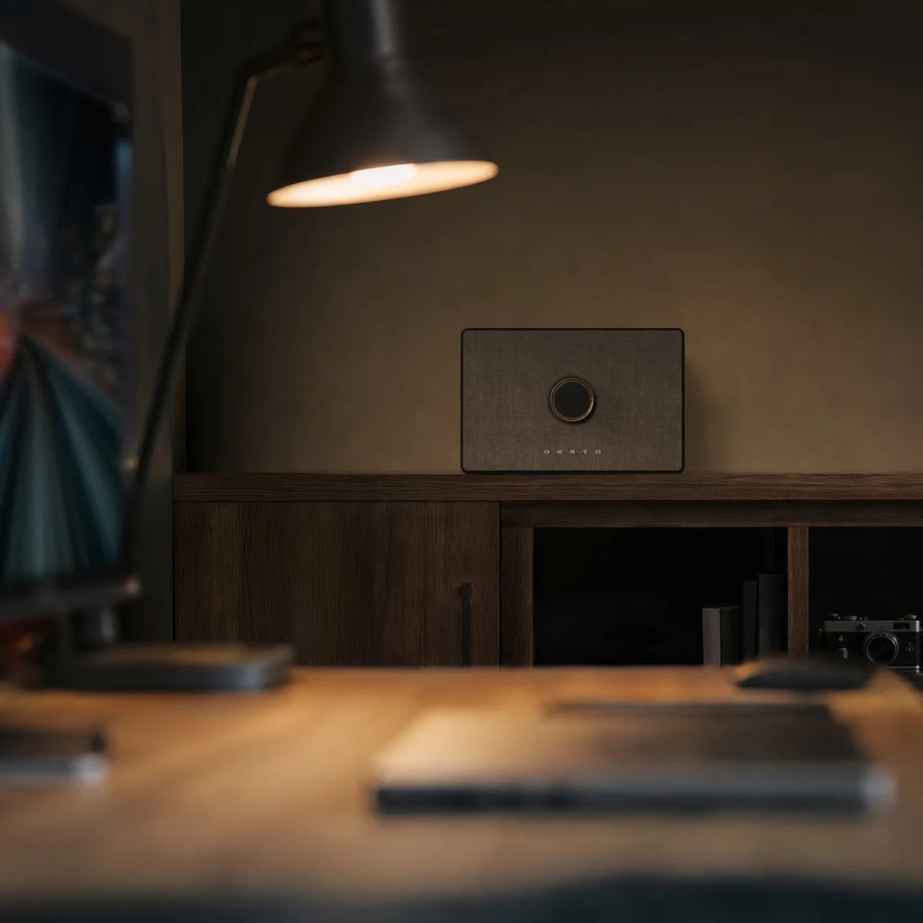 Onkyo GX-AiO 50 in black on a credenza in a dimly lit room