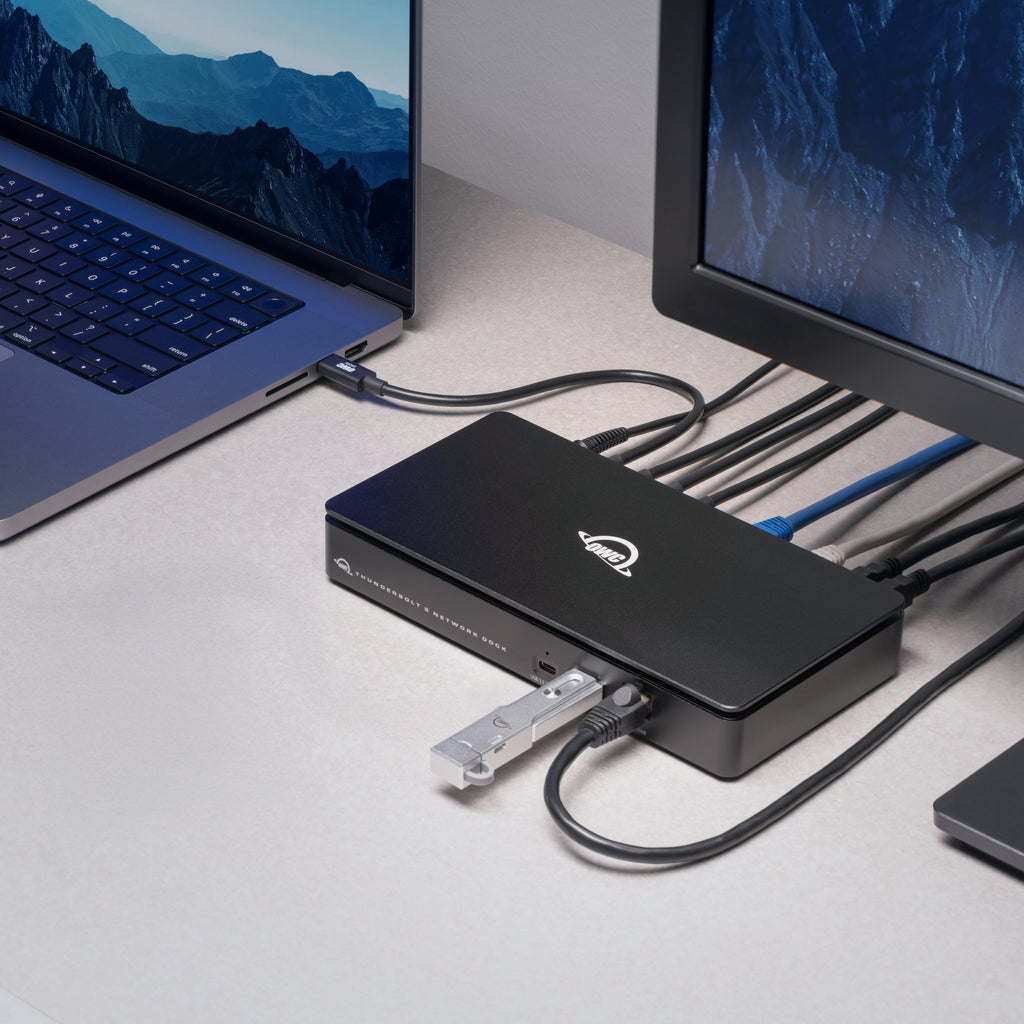 OWC Thunderbolt 5 Dual 10GbE Network Dock, on a desk connected to a laptop and display