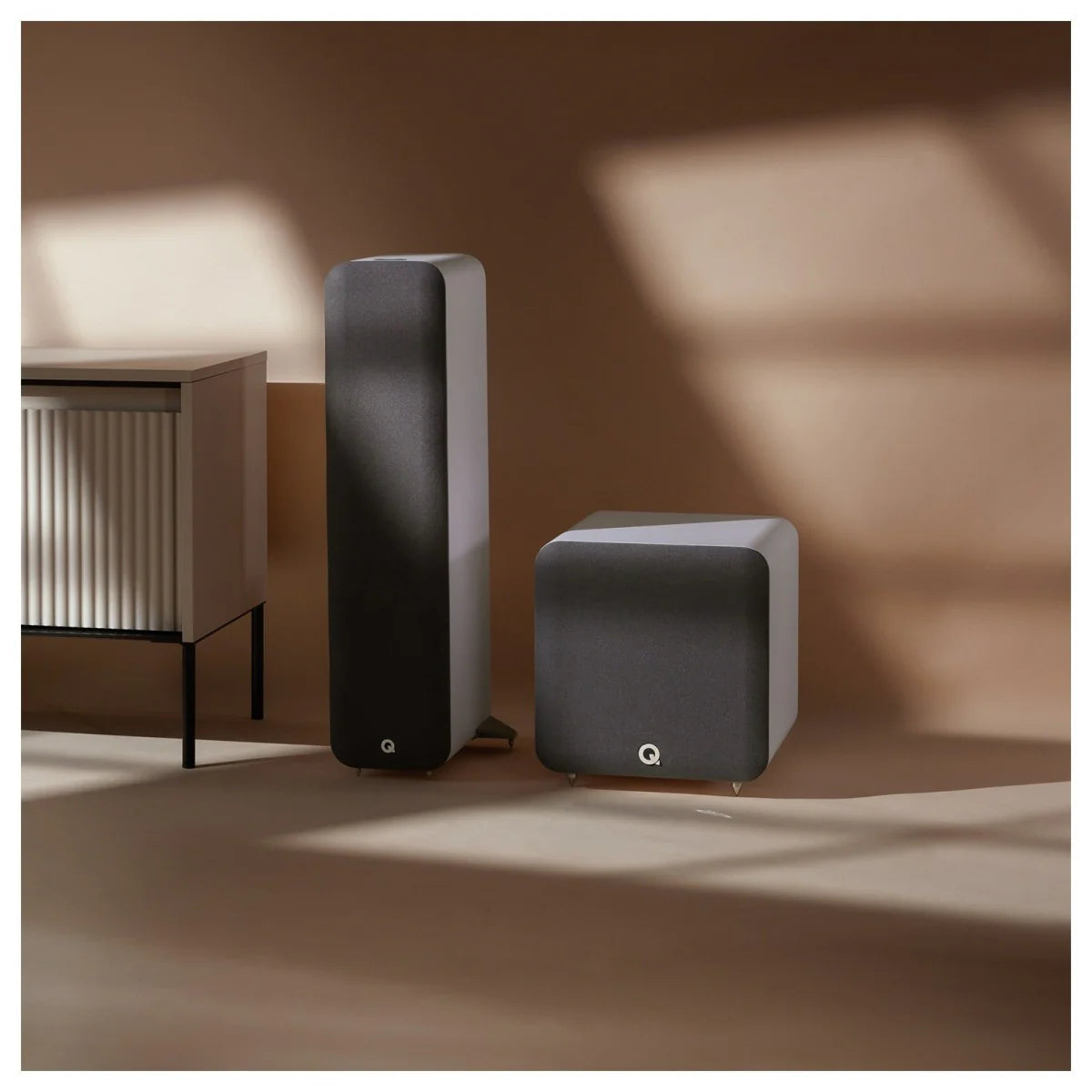Q Acoustics Q SUB80 subwoofer with sleek black enclosure and front-facing speaker grille, designed for deep bass sound.