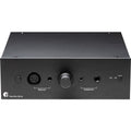 Pro-Ject Head Box DS3 B headphone amplifier and DAC with sleek black design and control knobs, set on a wooden surface.