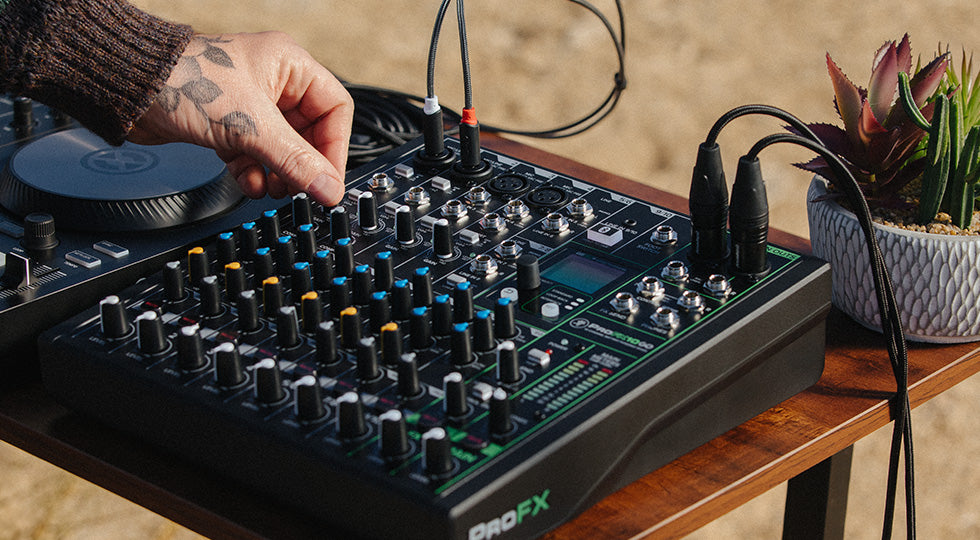 Mackie ProFX10 GO analog mixer with multiple input channels, knobs, and control sliders for live sound and recording setups.