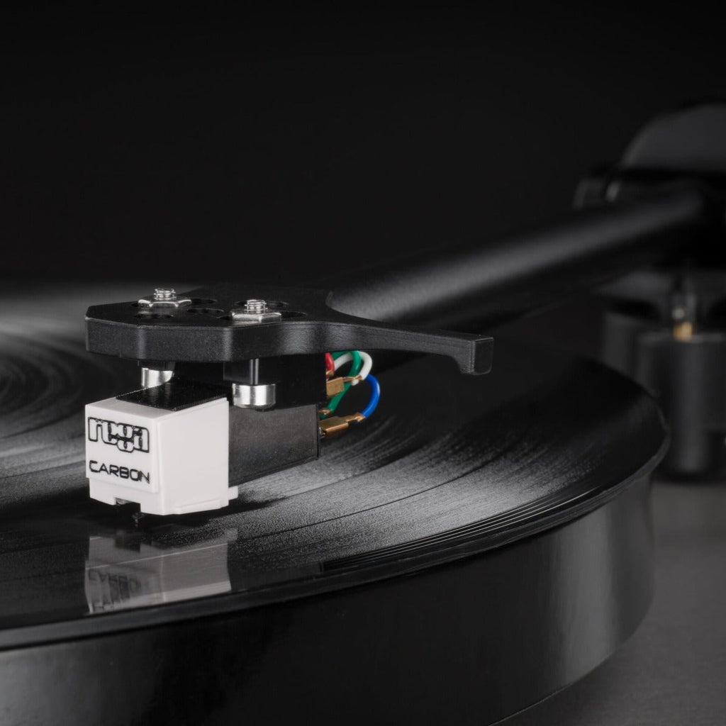 Rega Carbon MM phono cartridge mounted on a turntable, showcasing its sleek design and high-quality build for vinyl playback.