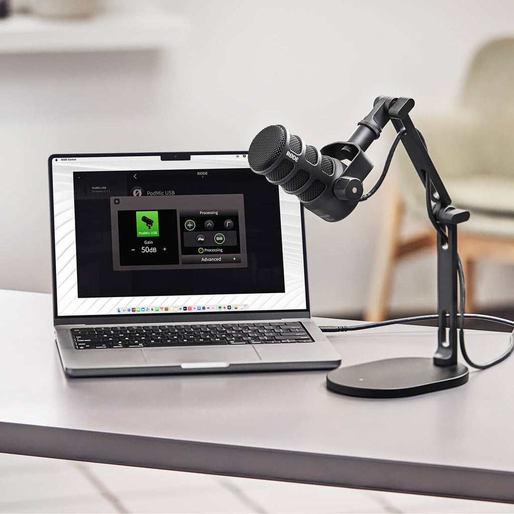 Rode Podmic USB microphone on a computer desk, showing its professional microphone design for podcasting and streaming.