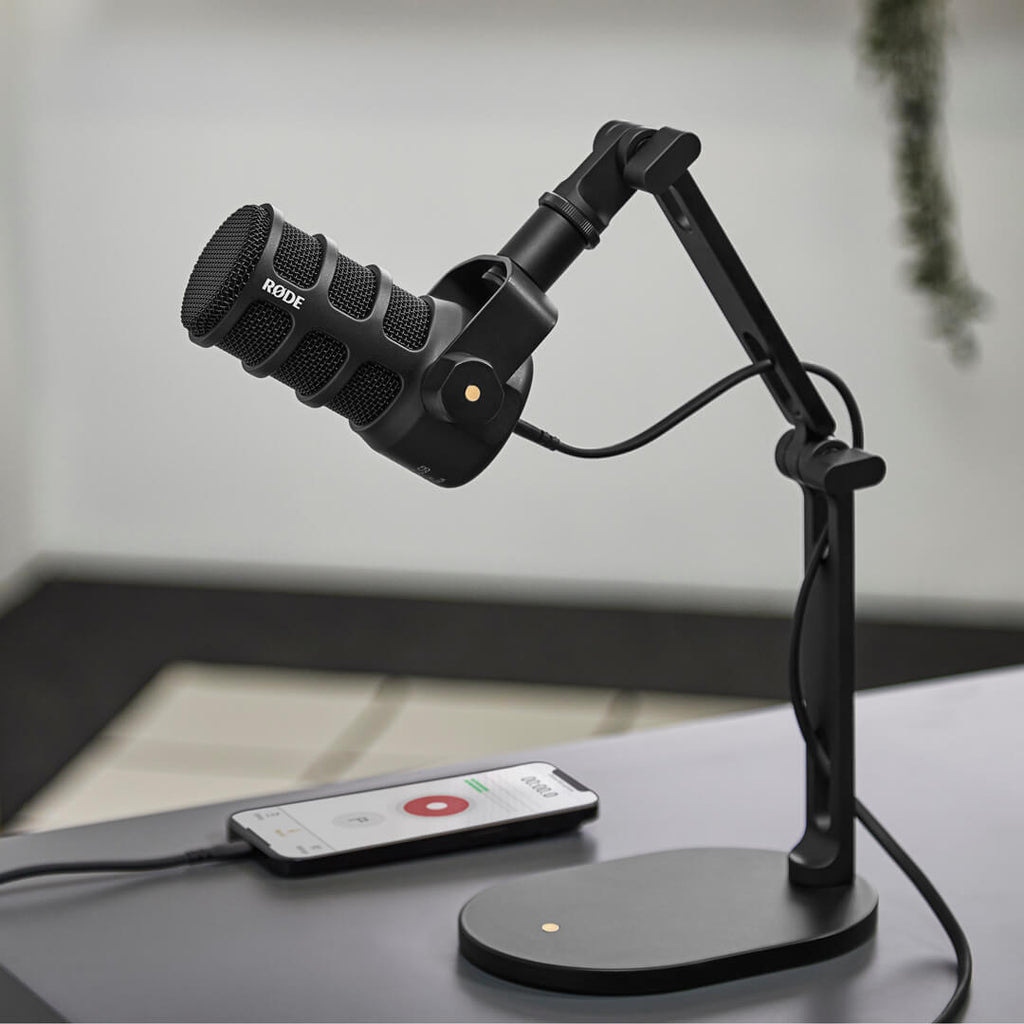 Rode Podmic USB microphone on a computer desk, ideal for podcasting and streaming with professional audio quality.