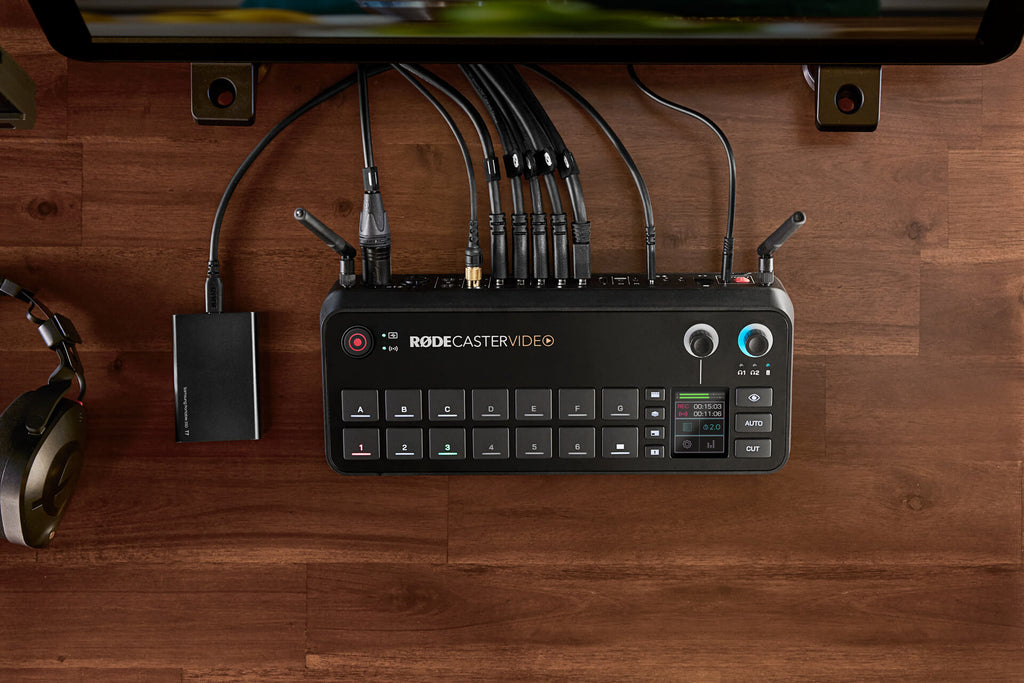 Rode RodeCaster Video editing controller with colorful RGB buttons and professional audio interface on a desk setup.
