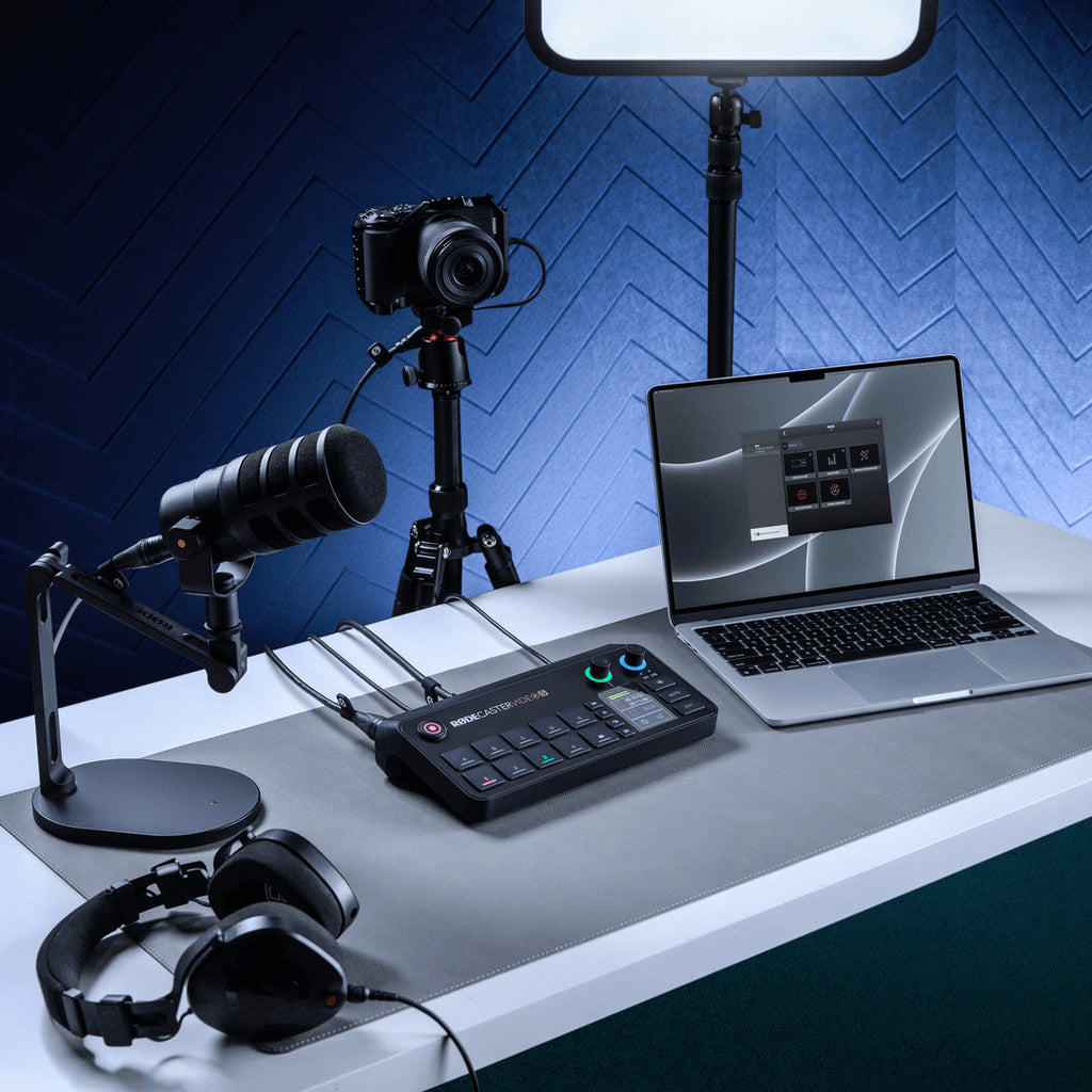 Rode RodeCaster Video S video editing controller with multiple buttons and knobs, placed on a desk with a laptop in the background.