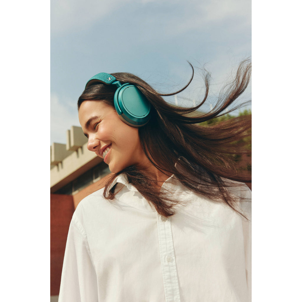 Sennheiser Momentum 4 Wireless headphones, lifestyle worn by a woman, petrol blue