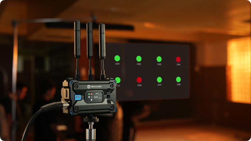 Hollyland Pyro S wireless video receiver connected to a camera, showing a sleek black device with digital display and antenna.