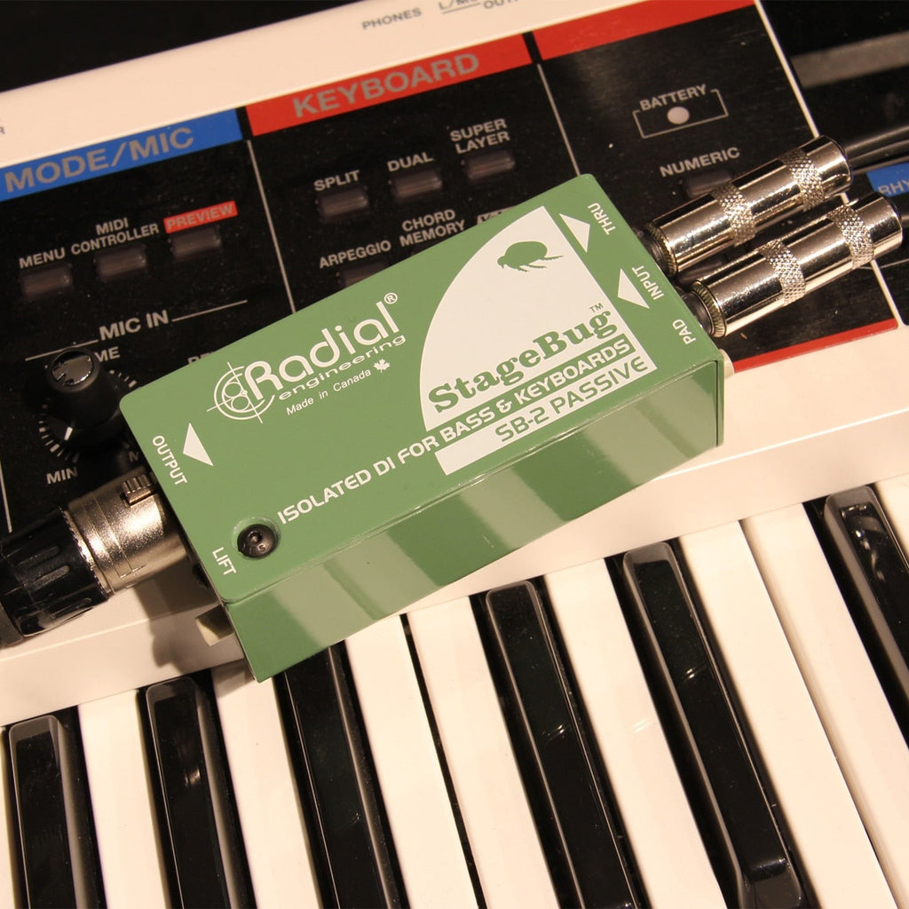 Radial Engineering StageBug SB-2 DI box connected to musical instruments, showing compact design and input/output jacks.