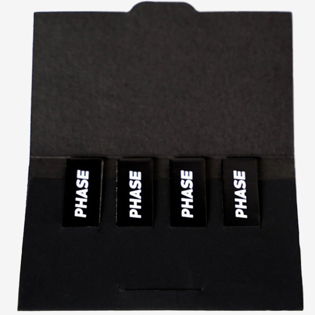 Open pack of Phase Magnetic Stickers for turntable accessories, featuring various designs on a black background.