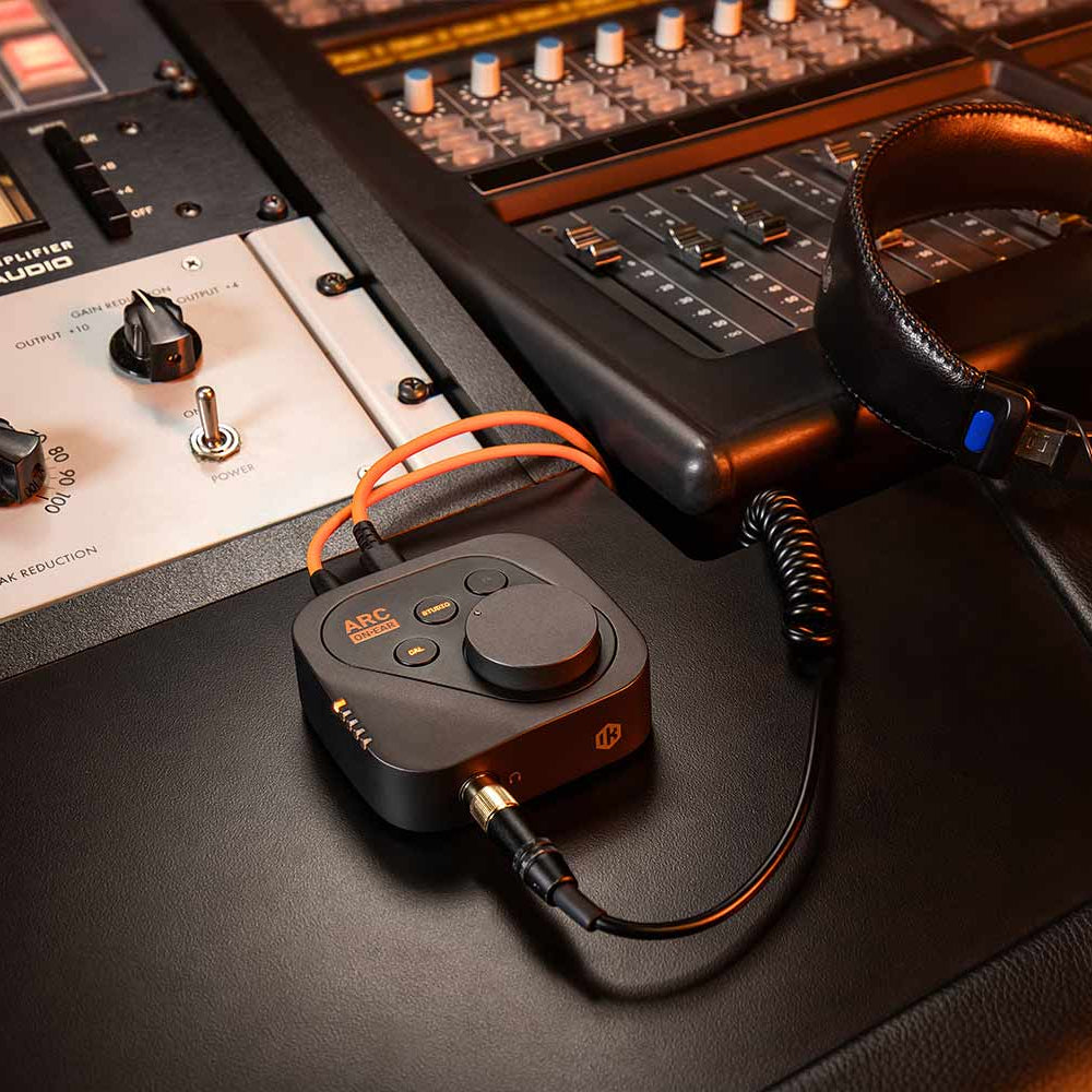 IK Multimedia ARC ON EAR headphone amplifier and DAC with sleek design, visible controls, and ear cups for high-quality audio.