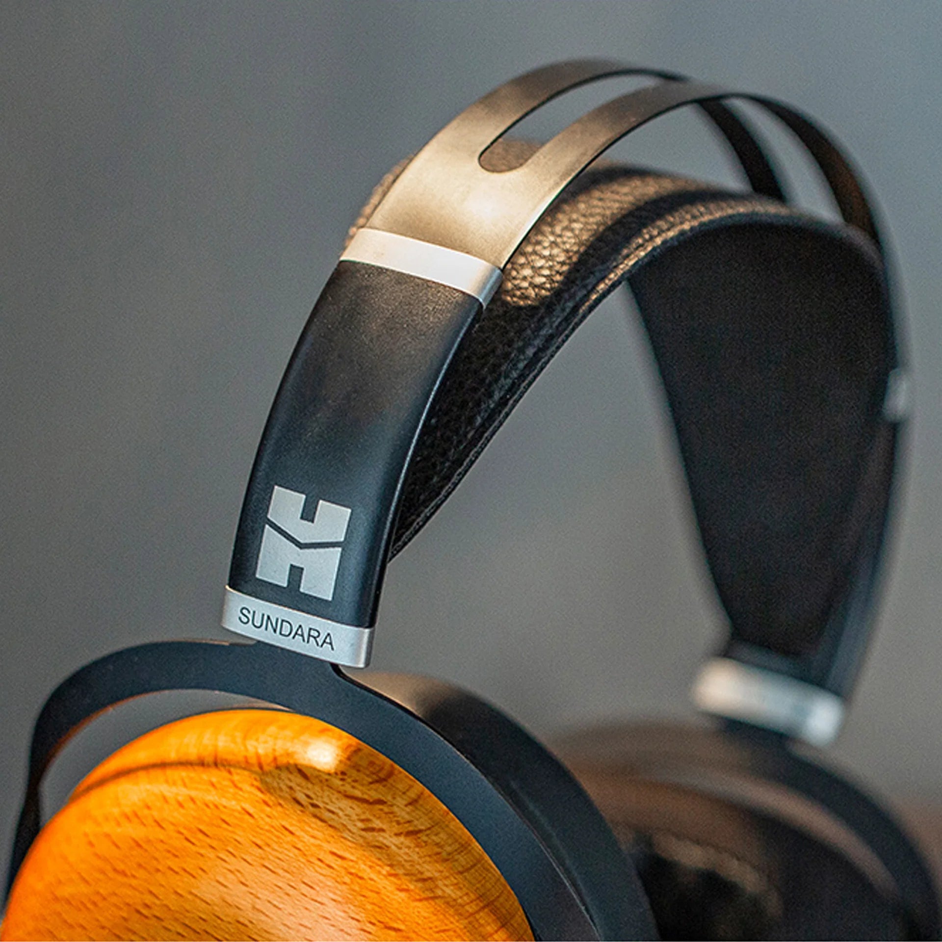 HiFiMAN Sundara closed-back wired headphones with black ear cups and headband, shown from a side angle.