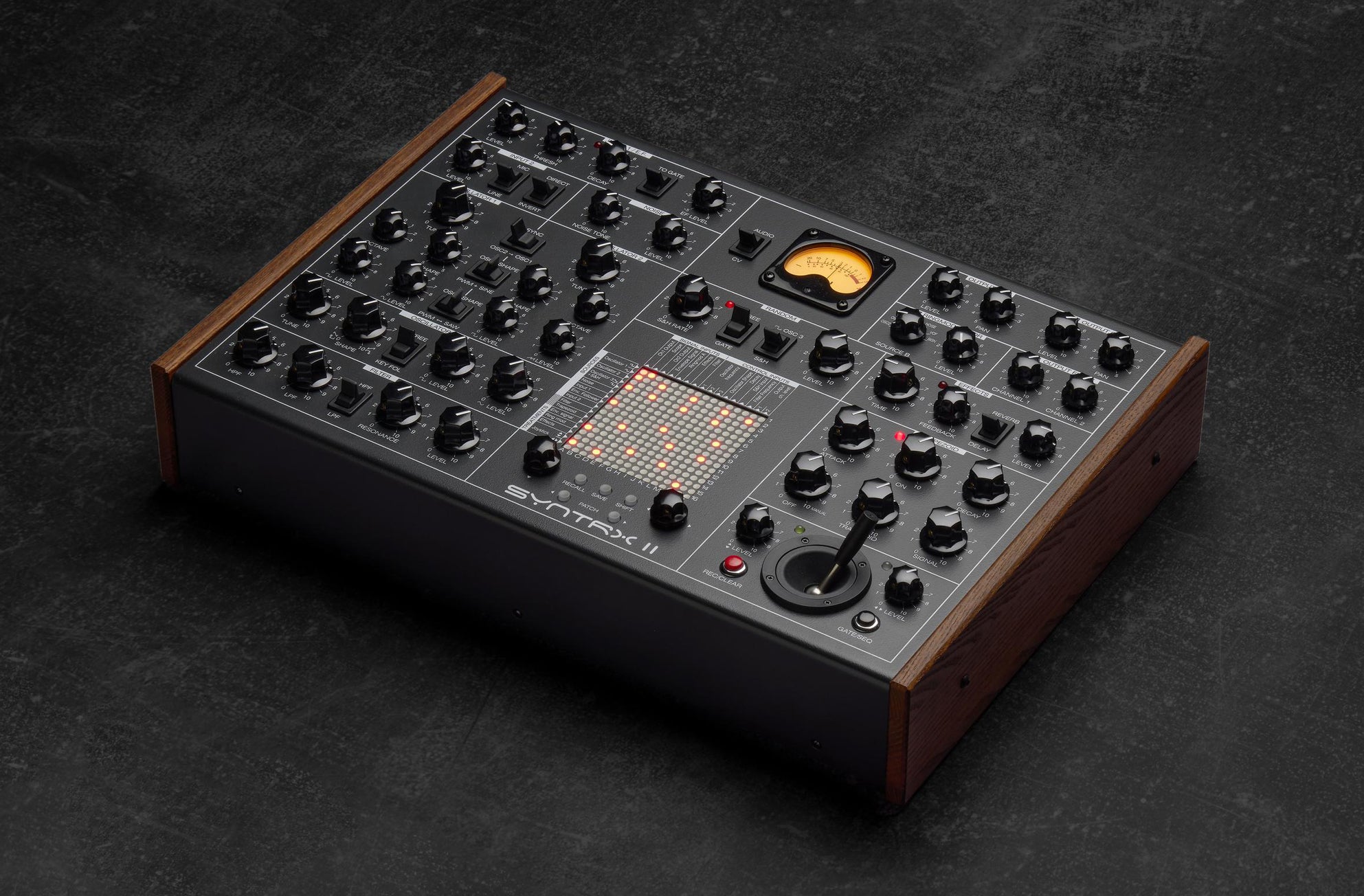 Erica Synths SYNTRX II desktop synthesizer with knobs, buttons, and display, showing its compact electronic music production interface.