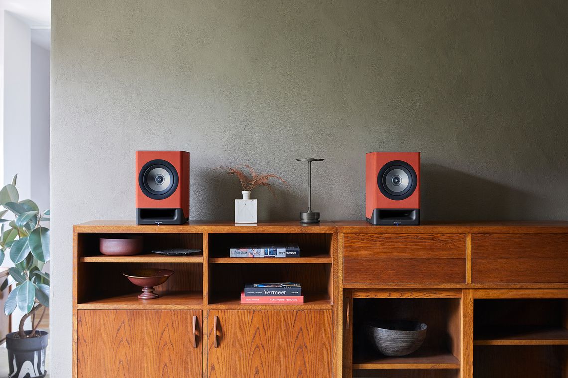 Technics SC-CX700 active bookshelf speakers in terracotta color, with control knobs and modern design.