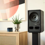 Vestlyd M-Stands holding a Vestlyd M6C Active in Black next to a sideboard