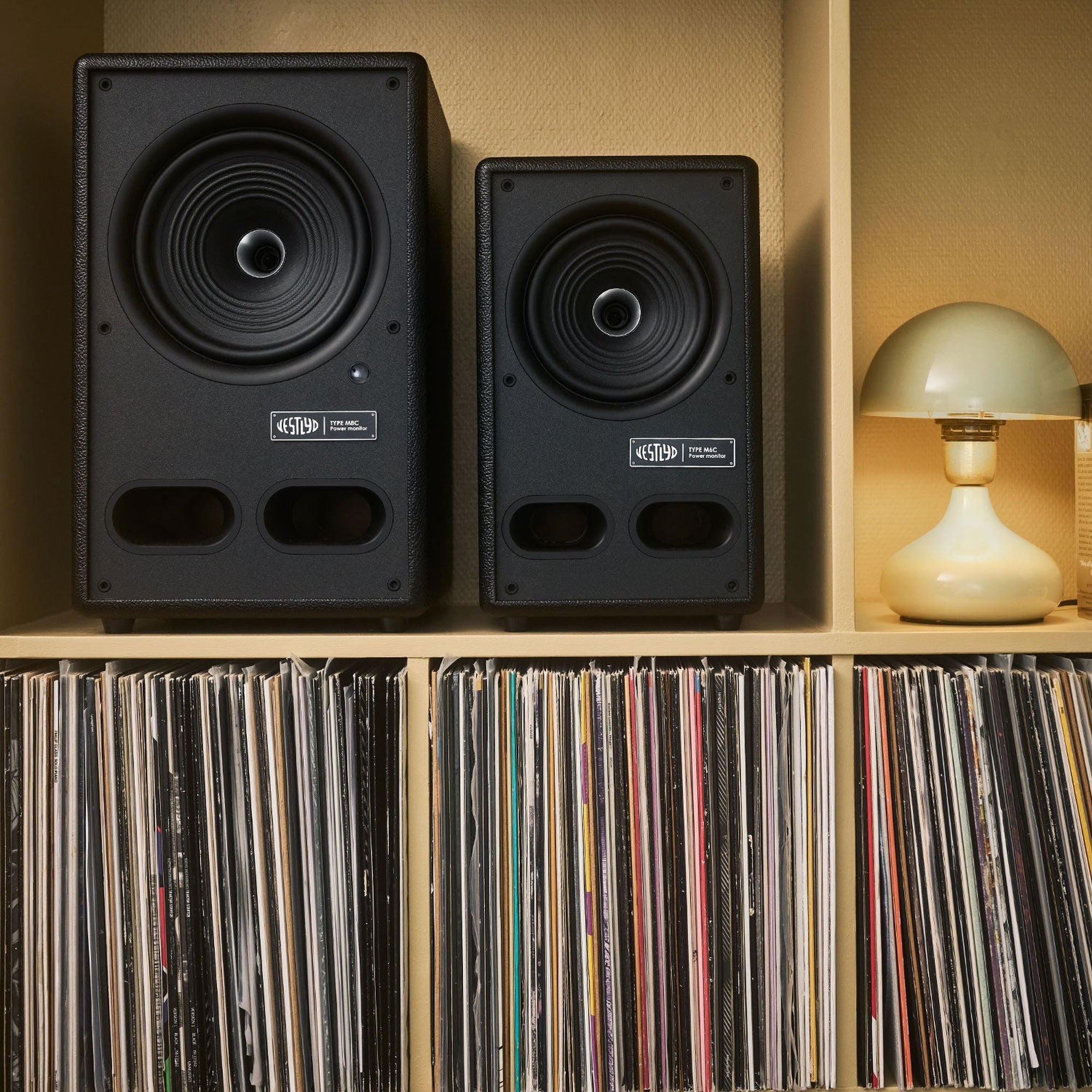 Vestlyd M8C Active and M6C Active in Black side by side on a shelf above vinyl records