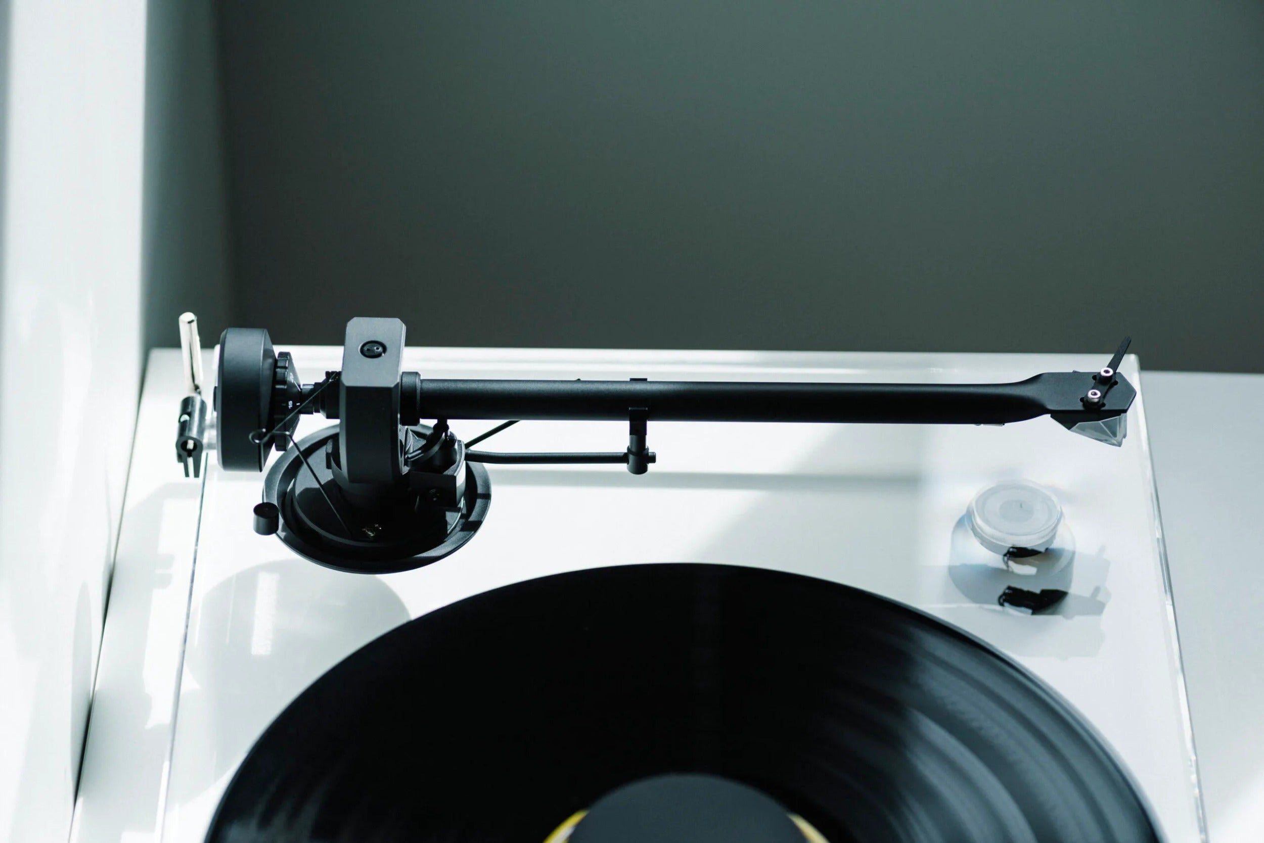 Pro-Ject XA B turntable with wooden plinth and tonearm, set in a modern living room for stylish audio setup.